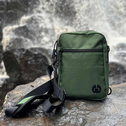 MYTHIC Phoenix Crossbody Pack in forest outdoors near waterfall, for travel, exploration, and everyday carry use.