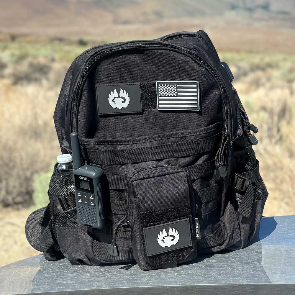 TORCH EDC Admin Pouch in black shown outdoors attached to tactical backpack with gear for hiking or travel use.