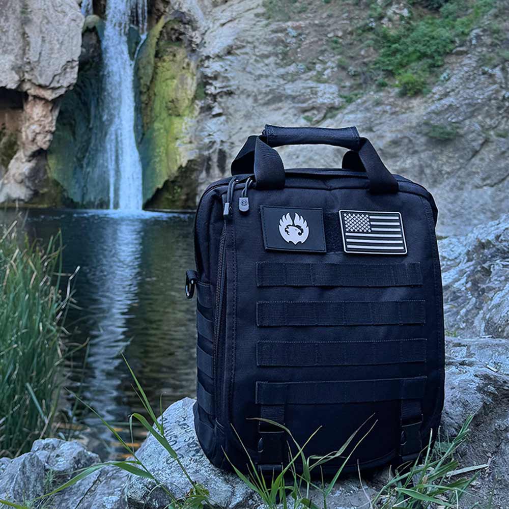 TORCH EDC Commuter Backpack V2 black outdoors near waterfall, showcasing sleek minimalist tactical design.